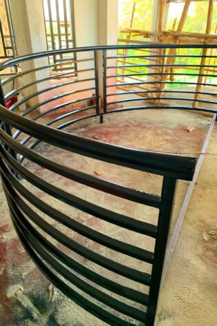 Customized curved steel balcony railing with a durable powder-coated finish, custom manufactured by Trust and Smart Metals.
